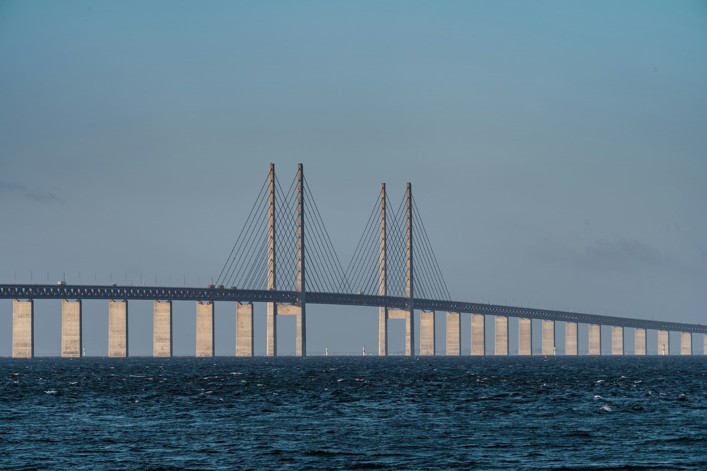 The Öresund Bridge between Malmö and Copenhagen, its cable-stayed span crossing open water under a pale sky